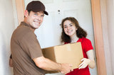 Happy customer receiving a package from a delivery man.  Focus on girl.   Man With Van Cranham 73 Front Ln 