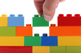 Hand adding another brick to a wall made from colored blocks Infigic Digital Solutions MICA Idea Labs, 3rd Floor, Rangkrupa Building, Near Parimal Garden 