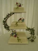 Purple, blue and white sugar flowers on ivy covered stand from Â£400 Sharon Lord Cakes Fiddlers Field Croydon Road 