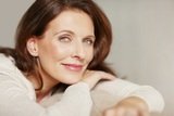 Portrait of a smiling middle aged brunette relaxing on couch, Medix Skincare & Laser Clinic, Melbourne