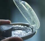 A close up shot of a hand holding Invisalign braces from the Dentistry at The Grove<br />
 Dentistry at The Grove 2142 Mountain Grove Ave 