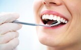 A close-up shot of a dental mirror looking at a patients teeth<br />
 Dentistry at The Grove 2142 Mountain Grove Ave 