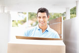 Happy young man with box moving into new home smiling, Storage Beckenham Ltd., Beckenham