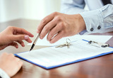 Young woman is signing financial contract with male realtor. Close-up. Buntrock Law Group 2158 N. Gilbert Road, Suite 119 