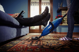 caucasian heterosexual couple, with woman doing chores using vacuum cleaner on carpet and lazy man on sofa with tablet pc. Horizontal shape, low angle view, Bromley Cleaner Ltd., London