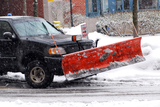 Snow plow truck on a road during a snowstorm Siesta Lawn Care 117 Buckingham St 