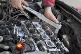 Mechanic fixing cylinder head with two camshaft of car engine with socket wrench, West Malling Garage Ltd, West Malling