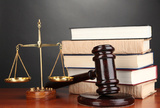 Wooden gavel, golden scales of justice  and books on grey background, GSB LPO Services, New Delhi