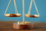 Golden balance scales on color background, closeup Law Office of Kevin Gupta 750 B Street 