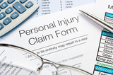 Close up of Personal Injury Claim Form with pen, calculator The Law Firm of R. Sam 9245 Laguna Springs Dr., Ste 200 