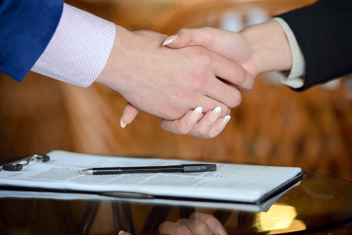 Businessman and woman hand signing contract paper Profile Photos of Attorney Amy Moore 111 South Mulberry St - Photo 3 of 4