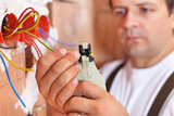 Electician installing electric wires in a new building - closeup on hands AAA Electric Company Inc 6525 Gunpark Dr. 