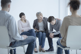 Psychotherapist supporting man who lost his wife. Support group meeting for people in mourning, Genesis DWI Services, Durham