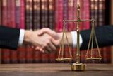 50278233 - justice scale on wooden table with judge and client shaking hands in background at courtroom, Immigration Lawyer Staten Island, Staten Island