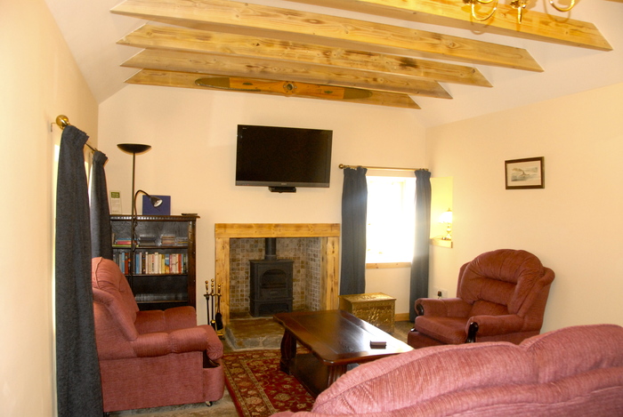 Lounge in Buxa Croft with wood burning stove and large screen Blu Ray TV Croft House sleeping 8 in 2 doubles and 2 bunk bed of Buxa Farm Chalets & Croft House A964 - Photo 4 of 18