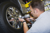 Mechanic repairing car on hydraulic platform, Soloco Auto And Tire Services, Oxon Hil
