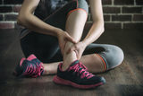 her ankle injured in gym fitness exercise training, healthy lifestyle concept, indoors wooden floor brick wall background Los Angeles Bicycle Law, Bike Accident Attorney 3415 S Sepulveda Blvd, Ste 1100 