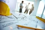 Image of engineering objects on workplace with three partners interacting on background, AMPtech Electrical Services, Dubai