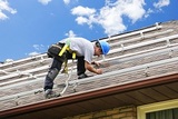 Man installing rails for solar panels on residential house roof, Output Electrical Group, Bundoora