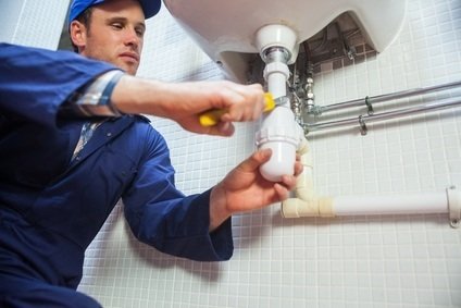 Frowning plumber repairing sink in public bathroom Profile Photos of Loodgieter RVH Onderhoud Rotterdam Benthuizerstraat 85-C - Photo 3 of 3